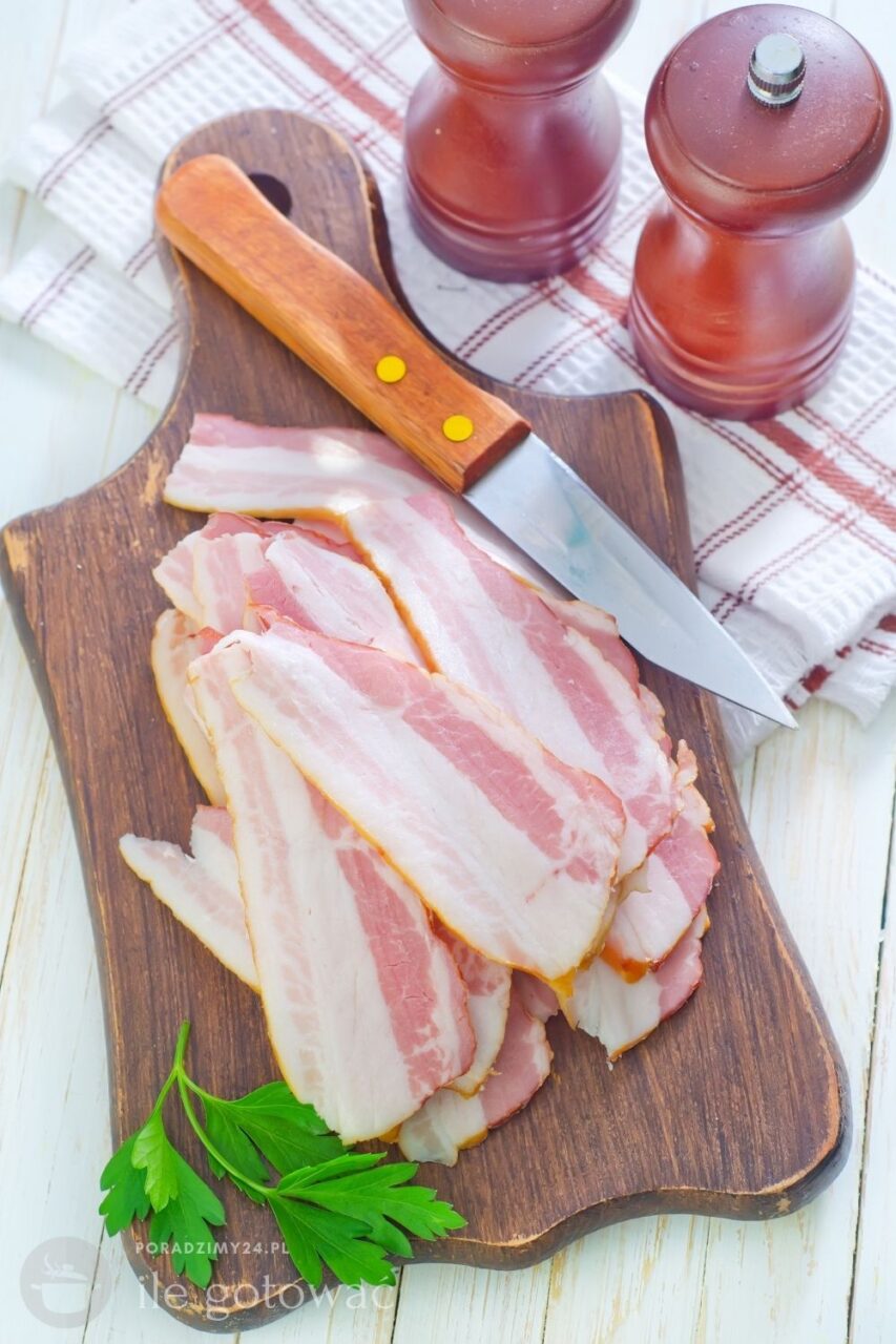 Gotowany boczek pokrojony w plasterki ułożone na drewnianej desce