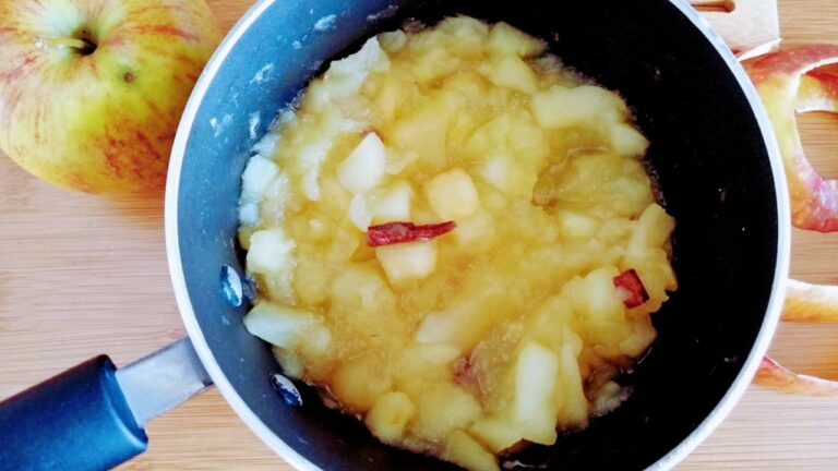 Duszone jabłka do szarlotki z kawałkami kory cynamonu w czarnym rondlu