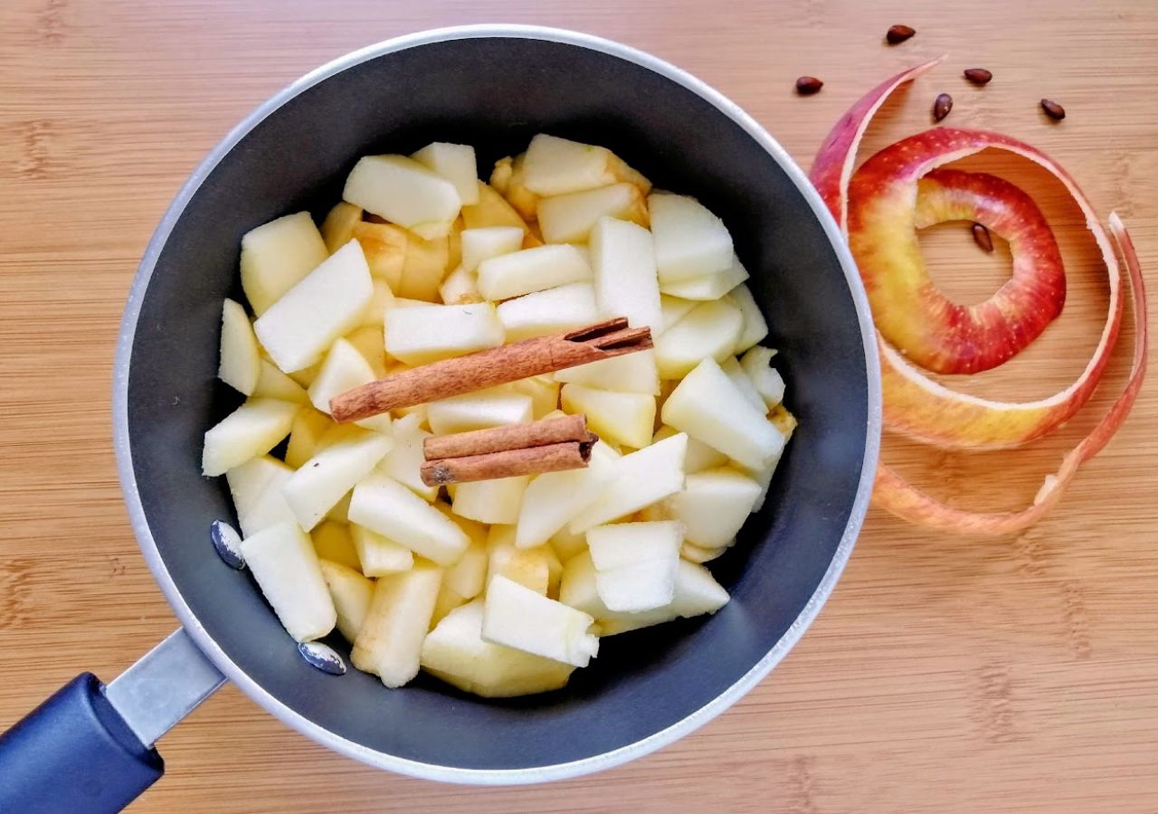 Pokrojone jabłka do szarlotki w rondlu, które następnie będą duszone