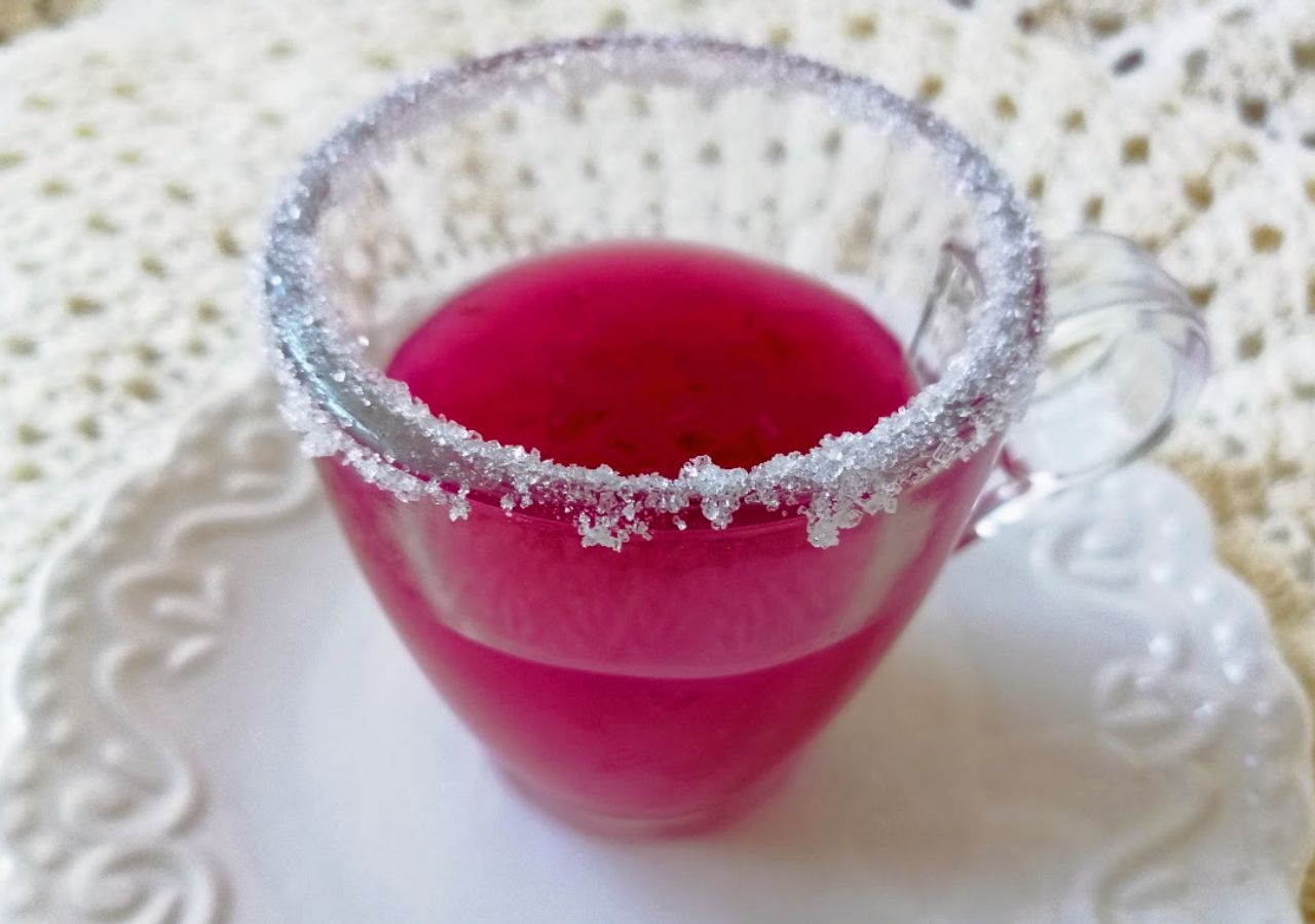 Domowy kisiel żurawinowy podany w szklanej filiżance na szydełkowej serwetce