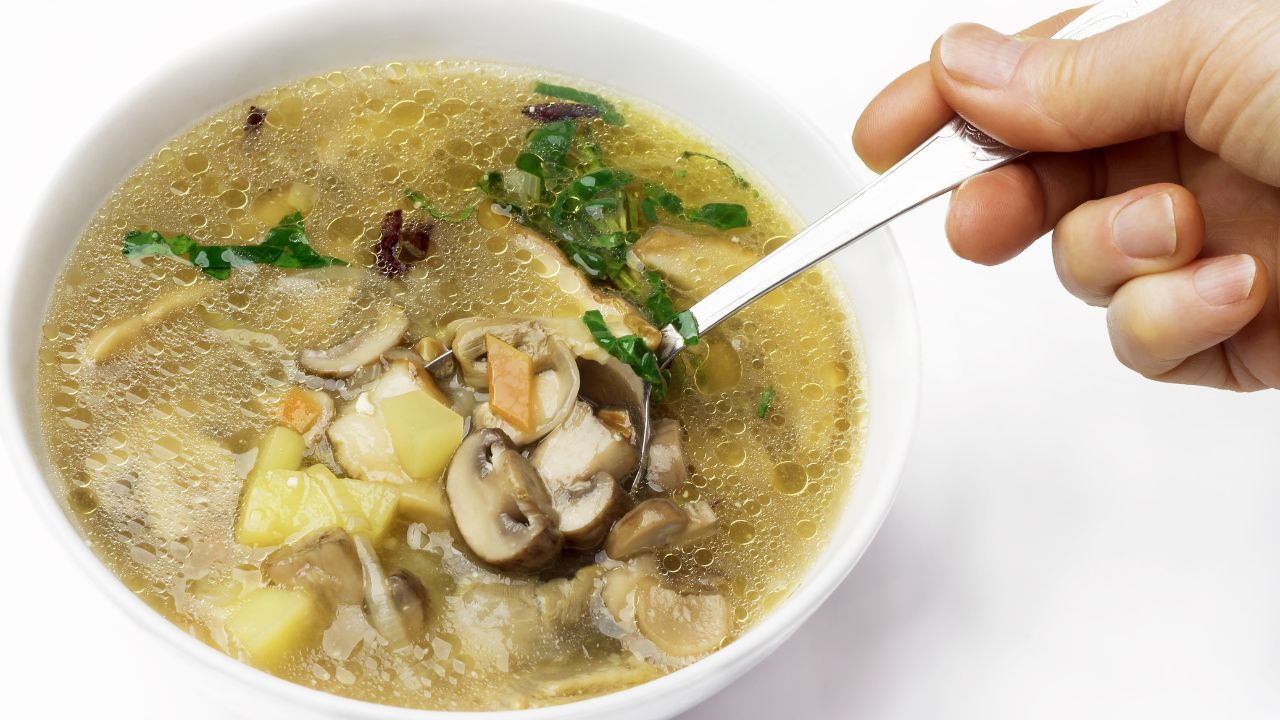 Zupa pieczarkowa w białej misce posypana natką pietruszki