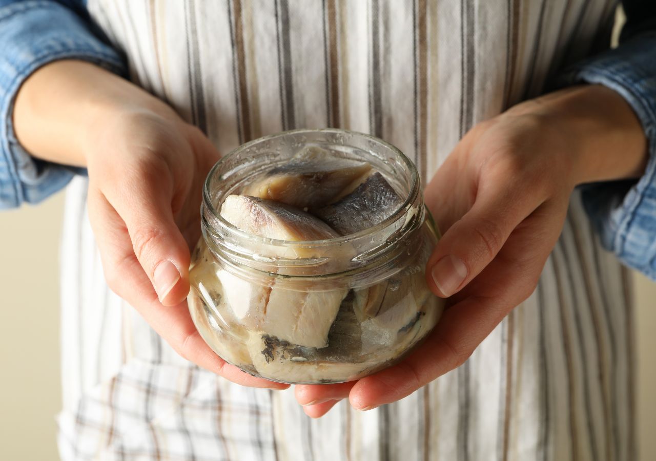 Pokrojone filety śledziowe ułożone w słoiku przed zalaniem marynatą