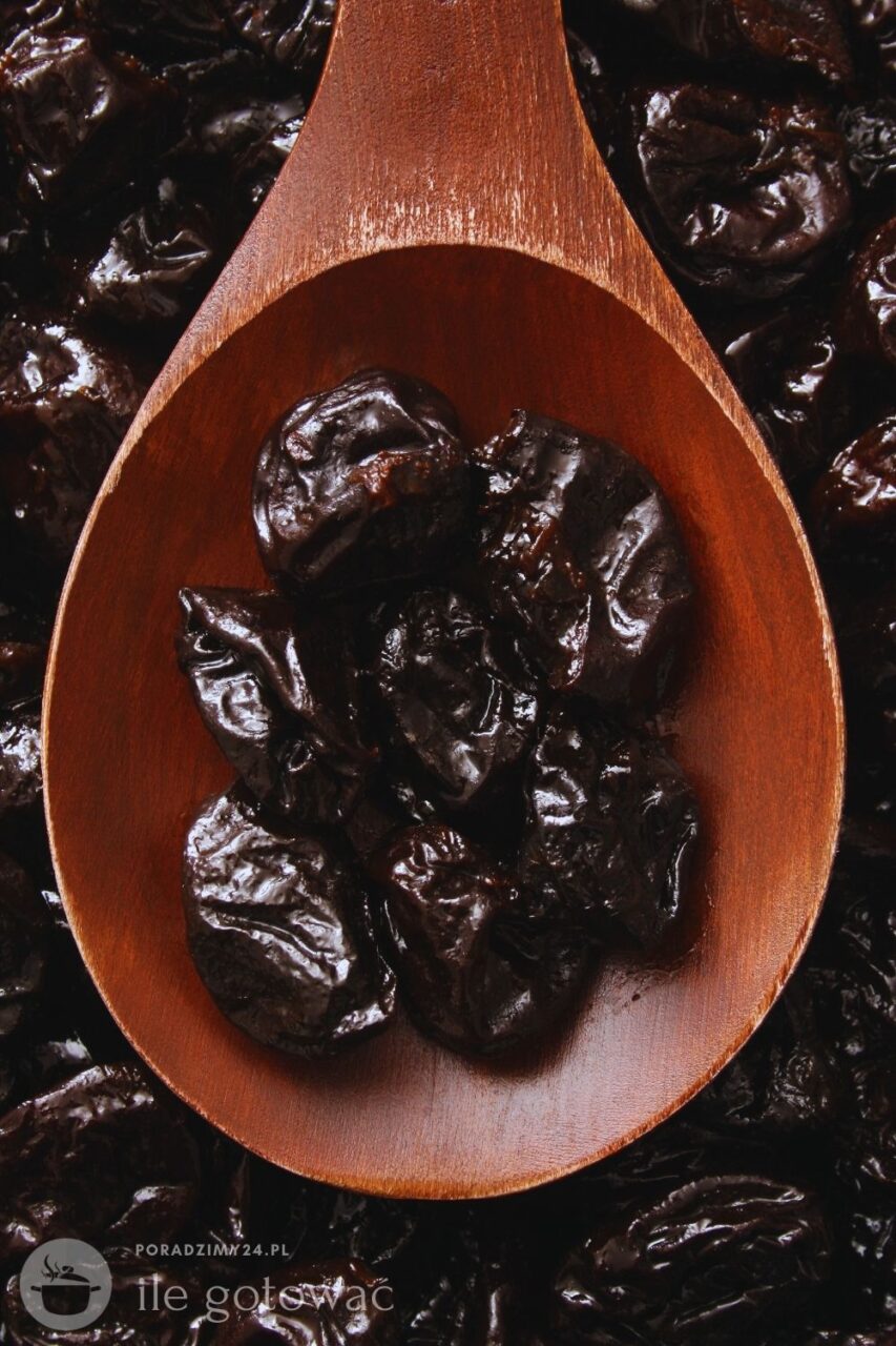 Suszone śliwki na drewnianej łyżce