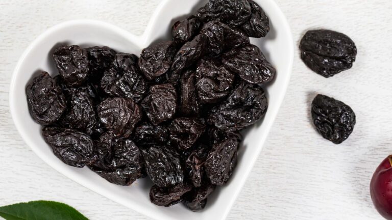 Suszone śliwki w białej miseczce w kształcie serca