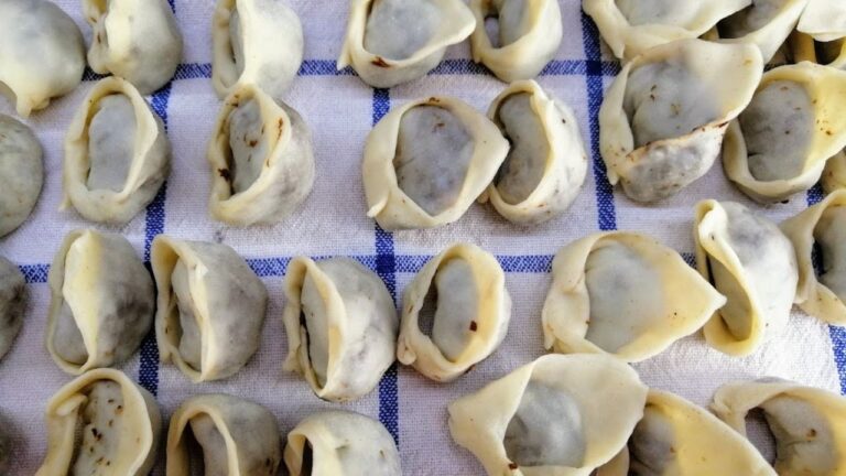 Ręcznie robione, domowe uszka z grzybami ułożone na lnianej ścierce